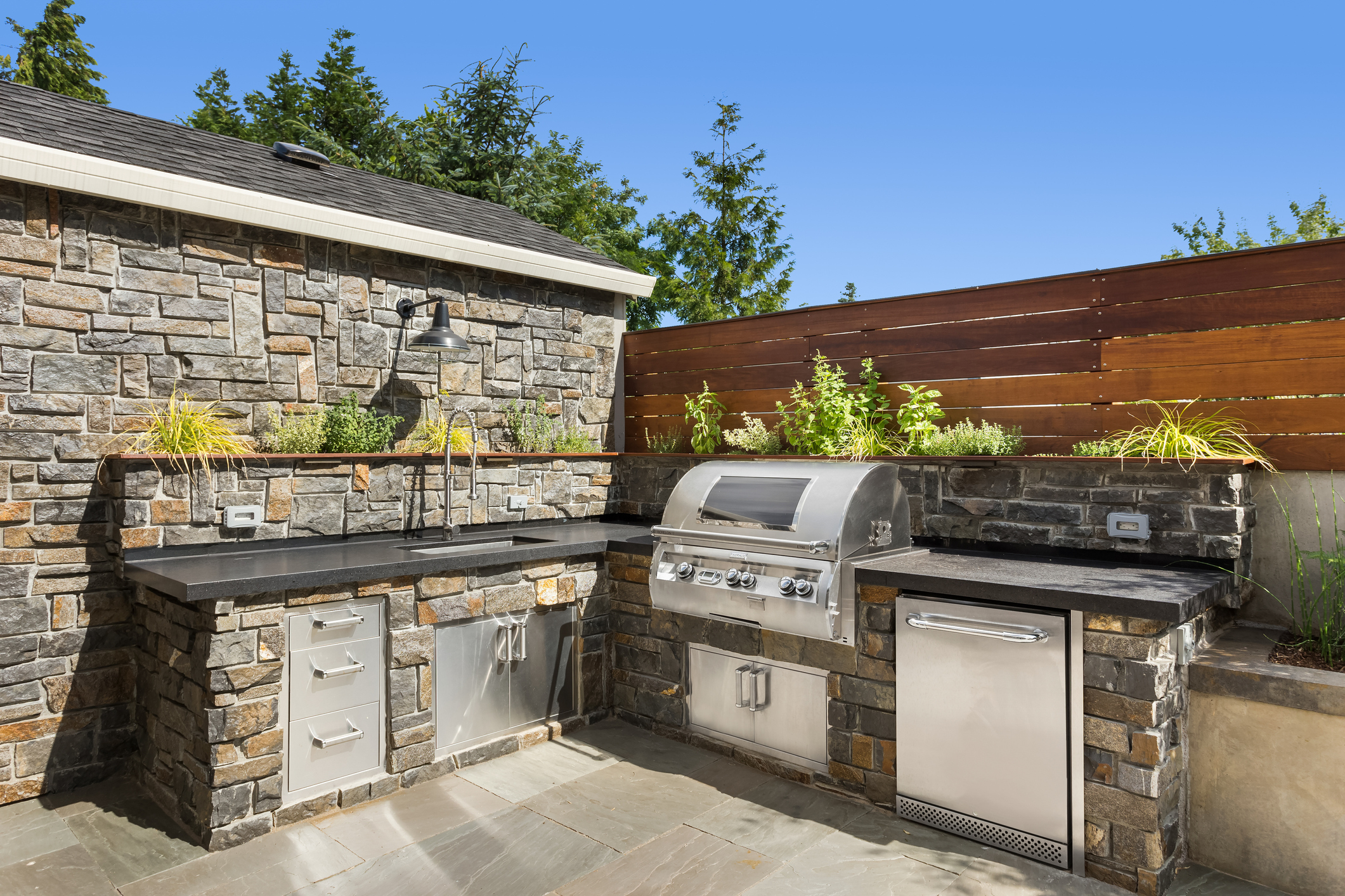 text: stone outdoor kitchen with built in grill and amenities