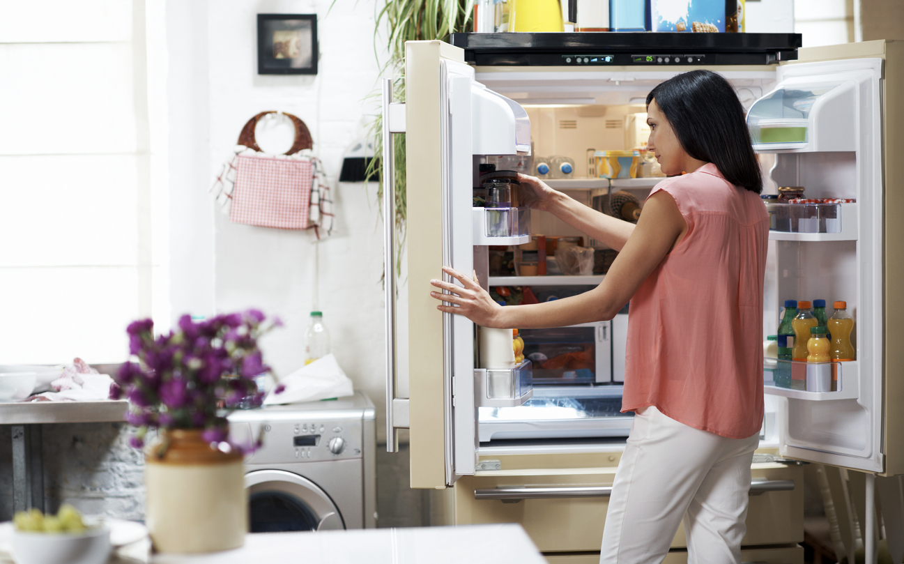woman looking in French door fridge