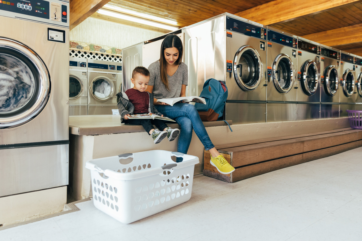 Mom and kid next to commercial washing machines