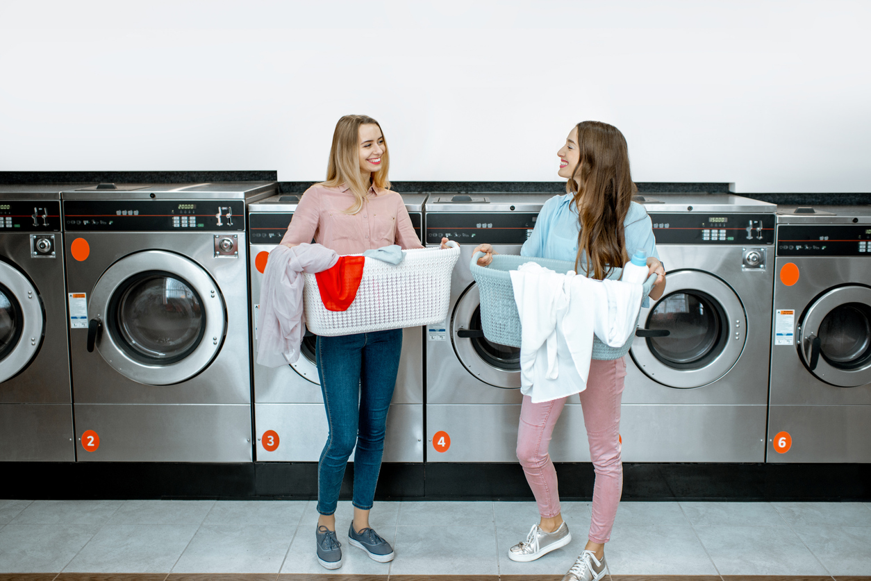 two woman talking in laundromat