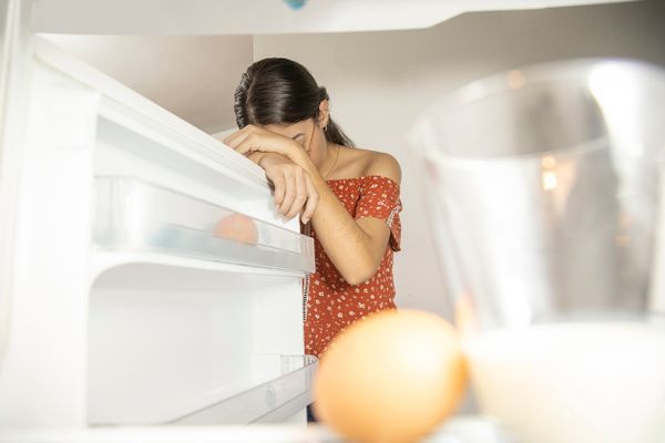 woman laying head on fridge