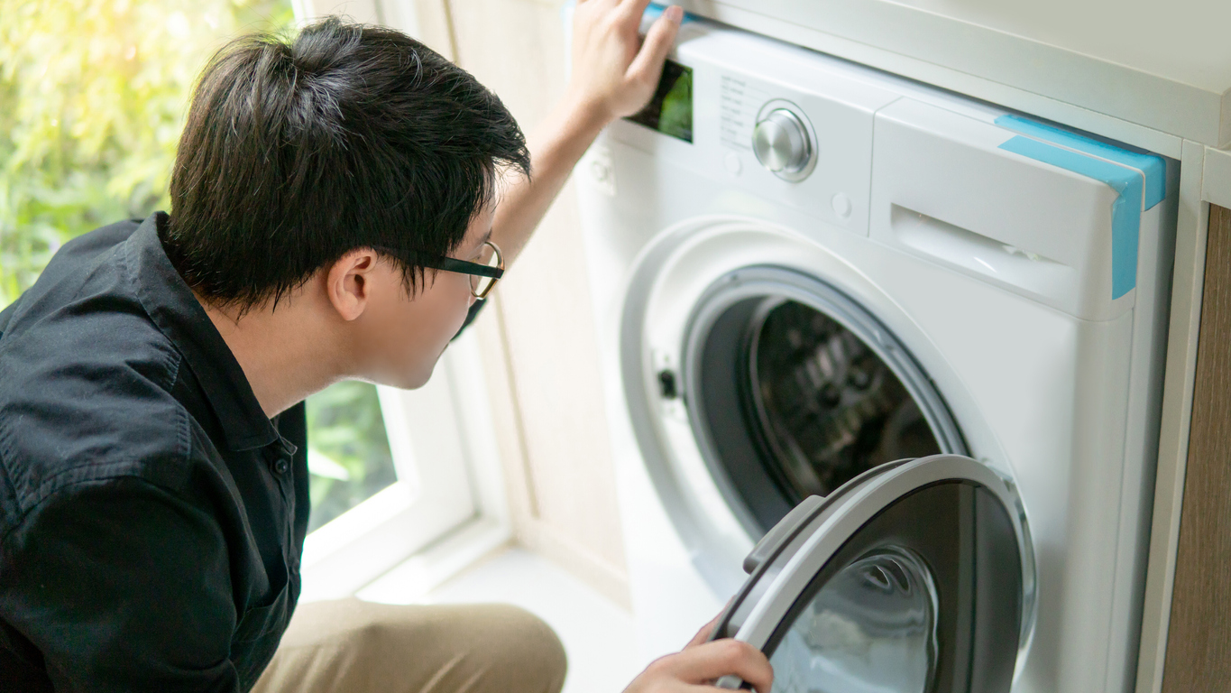 A man inspects his front loading dryer