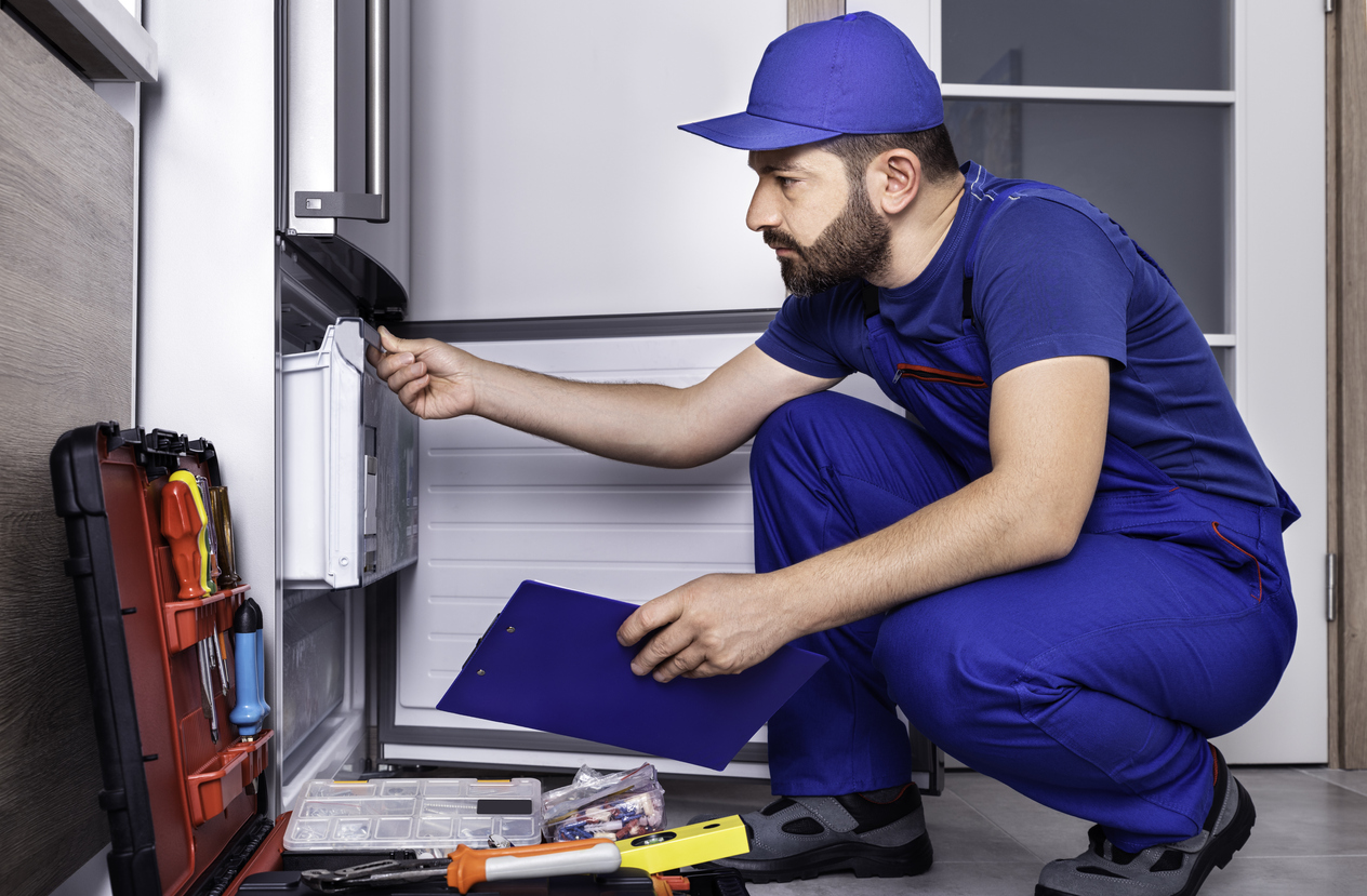 repairman replacing fridge parts