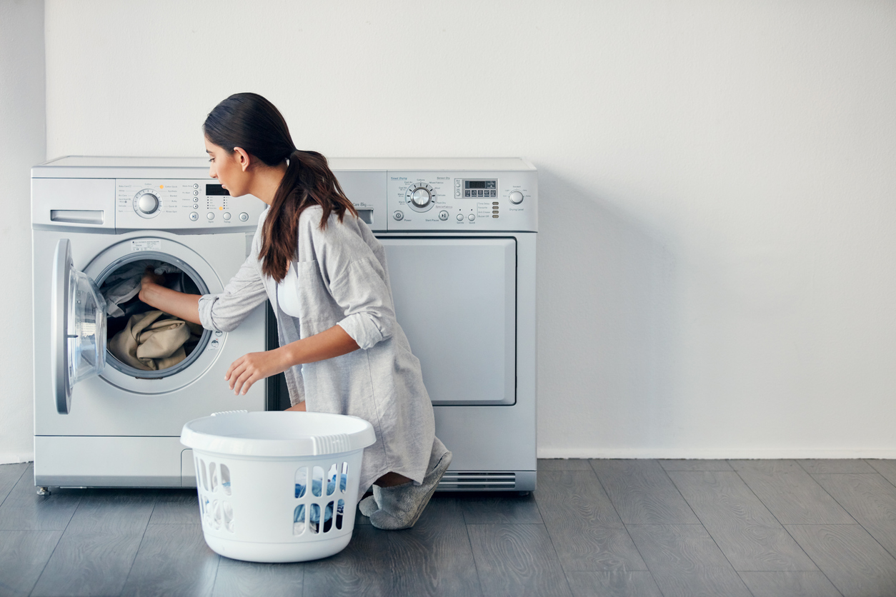 woman crouching at a front load washer