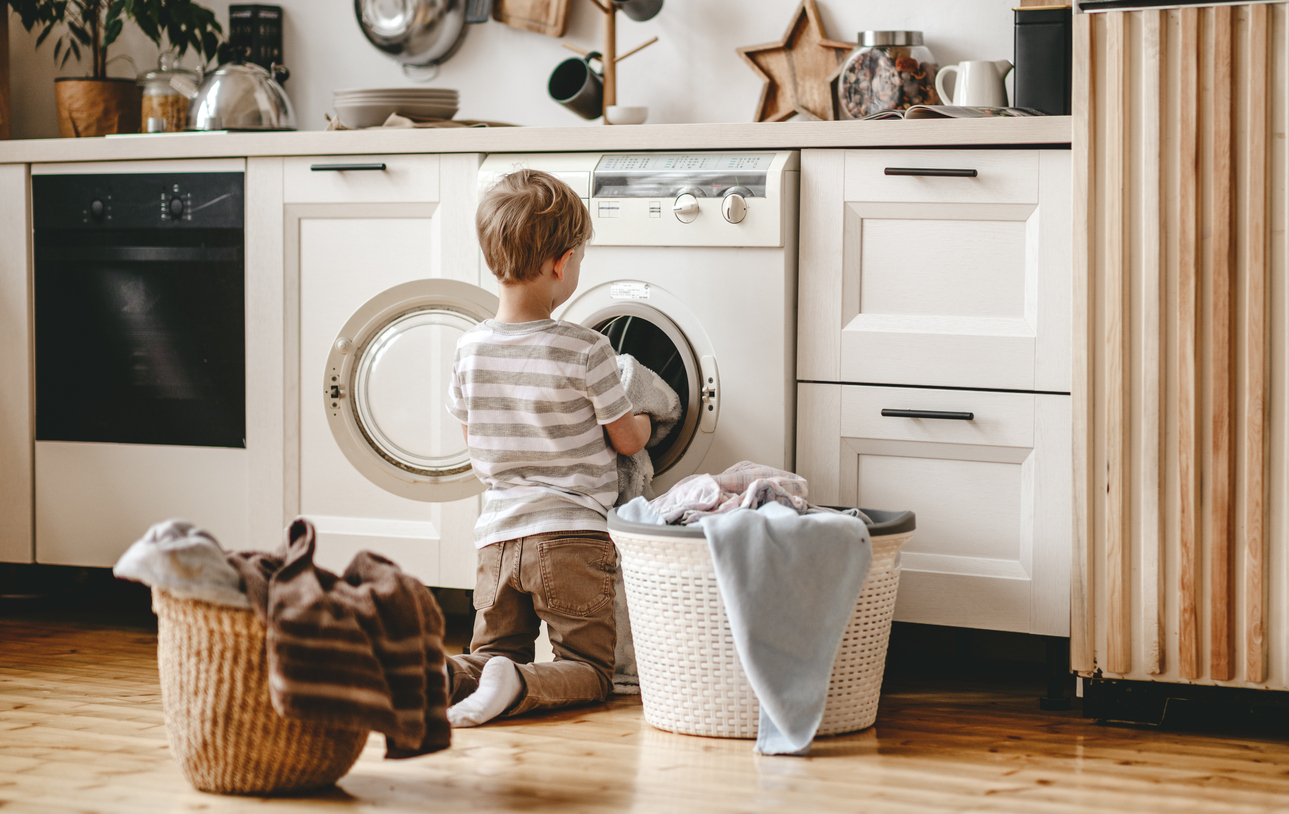 toddler loading a compact washer