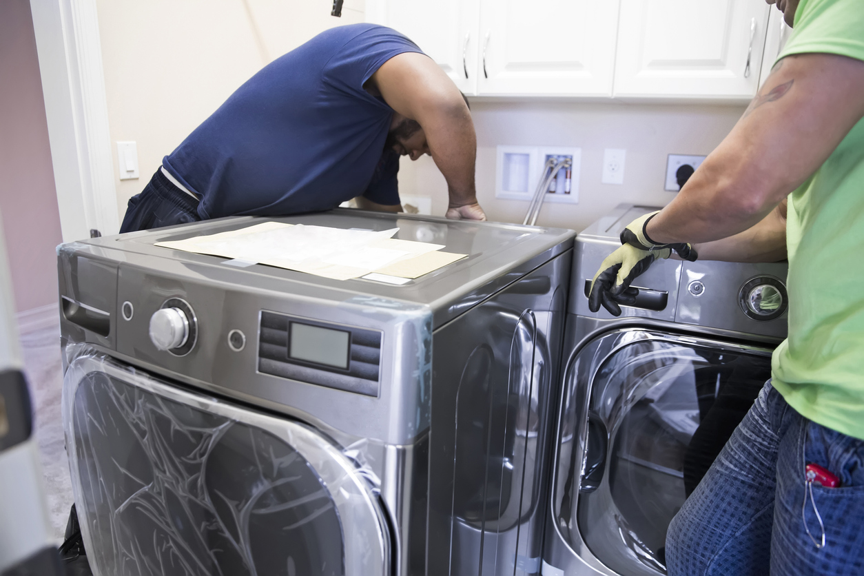 man measuring and installing washing machine