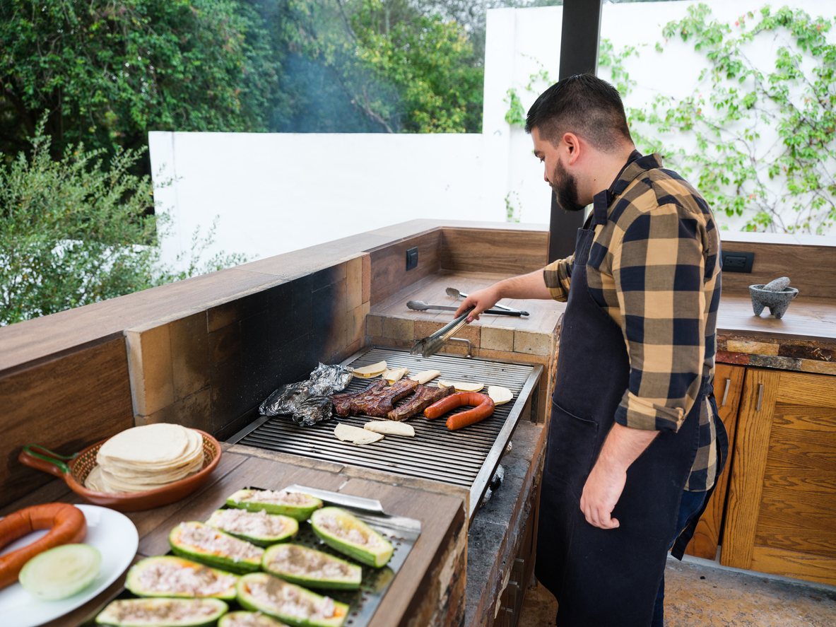 man grilling in an outdoor kitchen