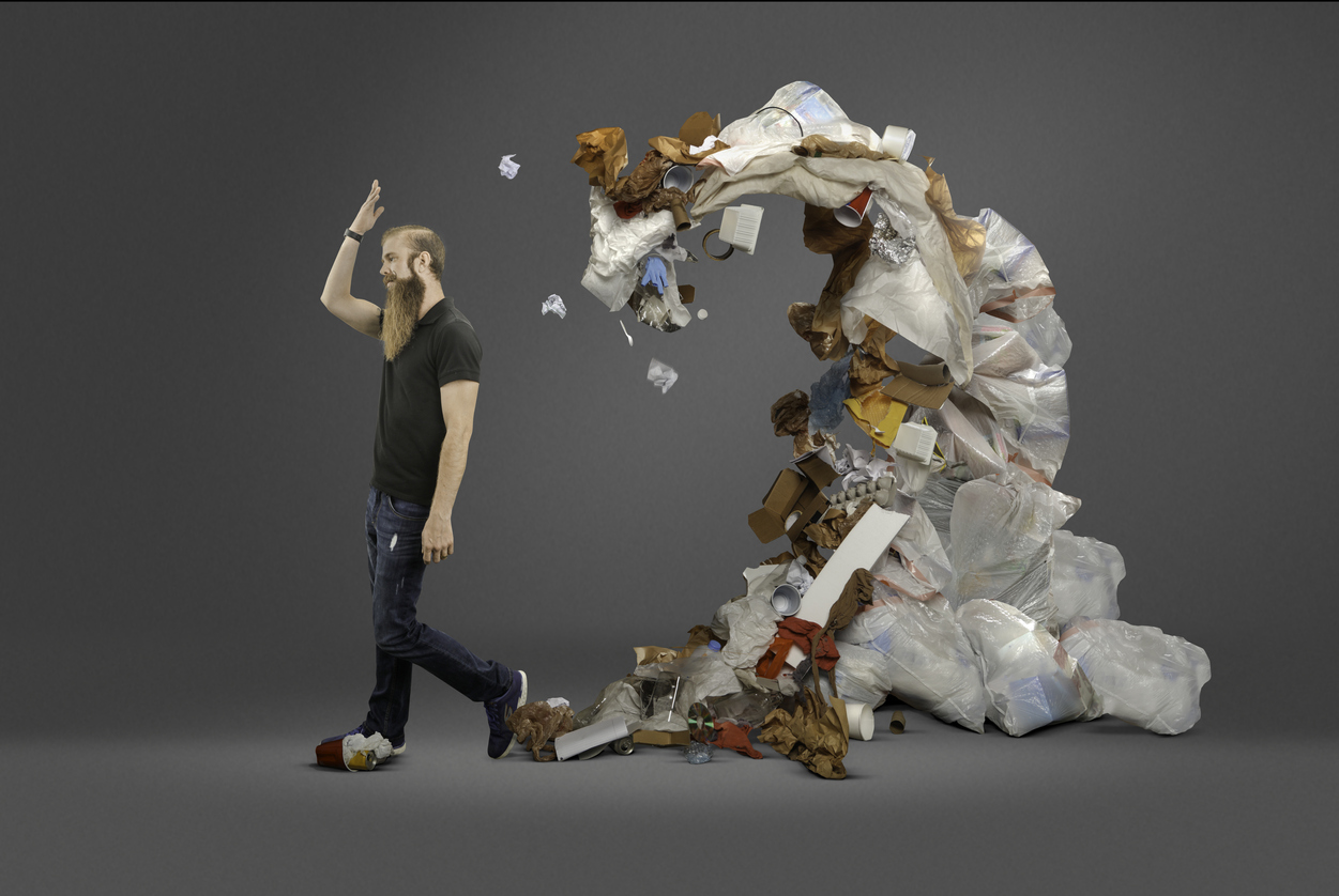 man throwing trash into a pile behind him