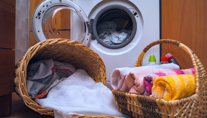Folded towels in a basket as more clothes are taken out to fold