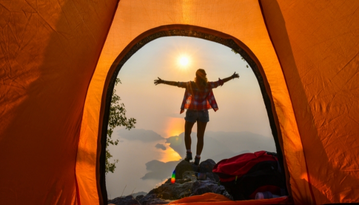 Woman greeting the sun; view from inside the tent