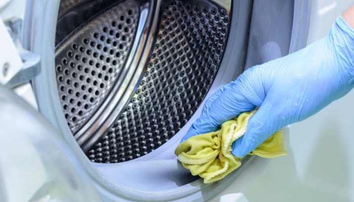 Closeup of hand inspecting the washer door seal