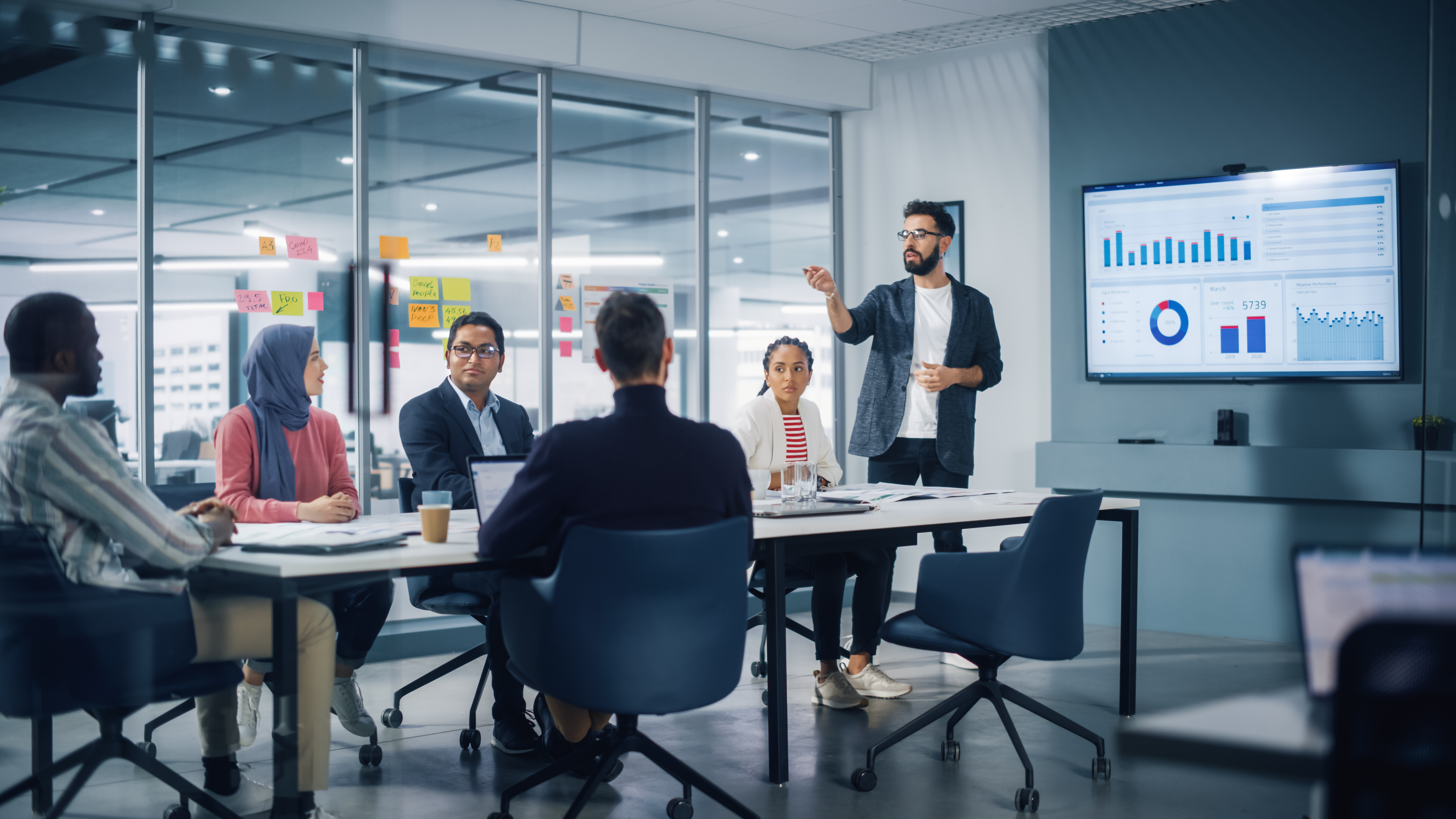 boss and employees going over work in conference room 