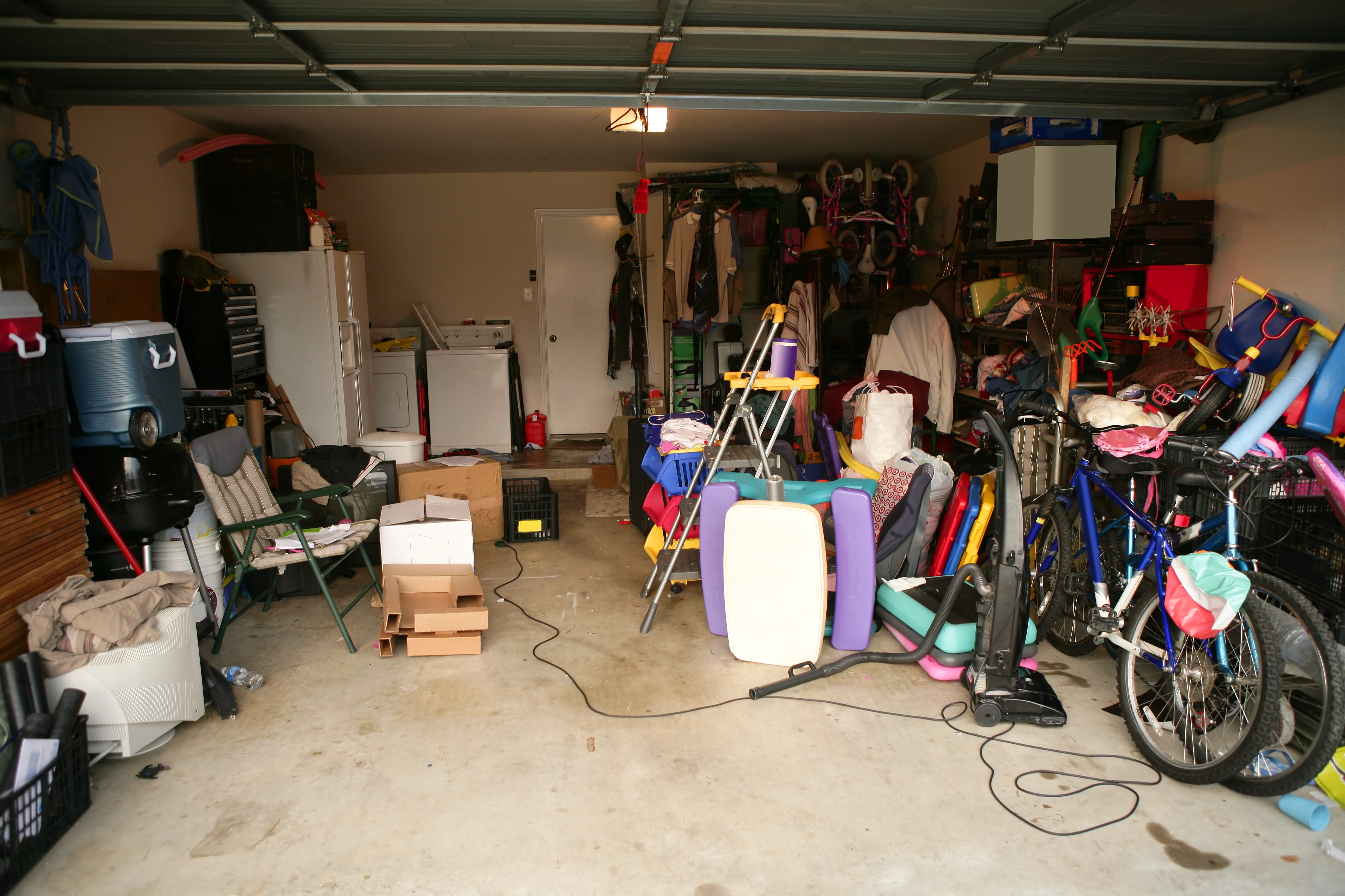 cluttered garage with refrigerator