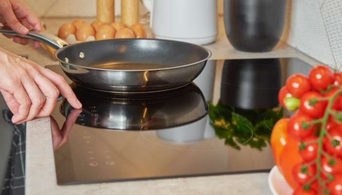 Closeup of someone turning on their induction cooktop