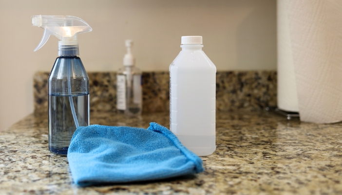Closeup of rubbing alcohol next to a spray bottle
