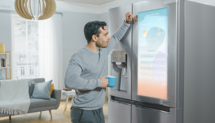 A man checking out the weather on the refrigerator smart panel