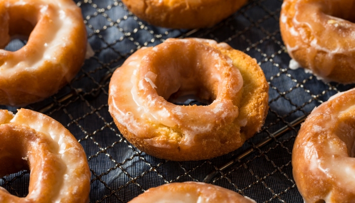 Old fashioned cream cheese doughnuts on a cooling rack. 
