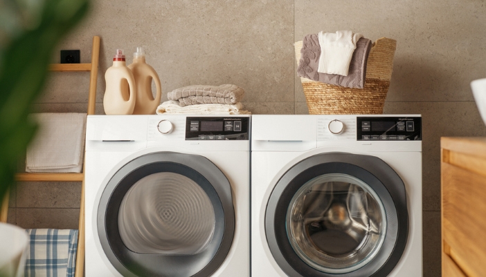 A modern laundry room with natural and plant accents. 