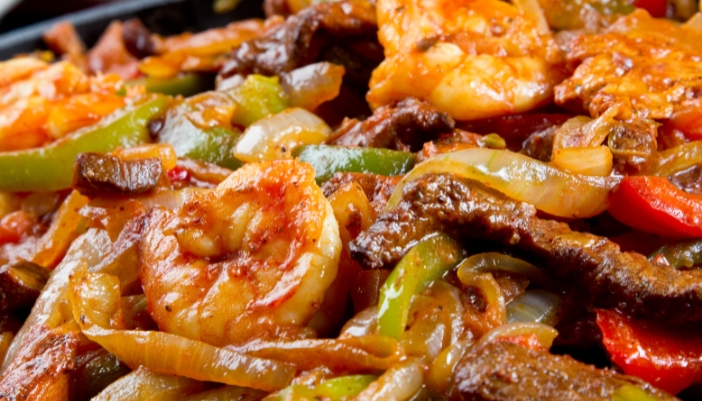 A close-up of the toppings for shrimp fajitas. 