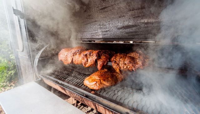 Front view of meat being smoked on a large smoker
