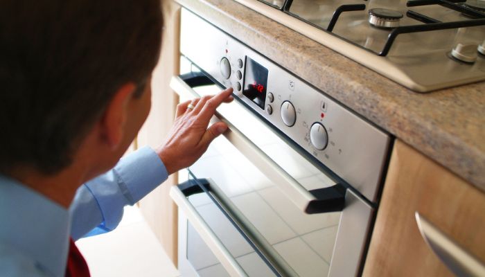 Man operating convection oven