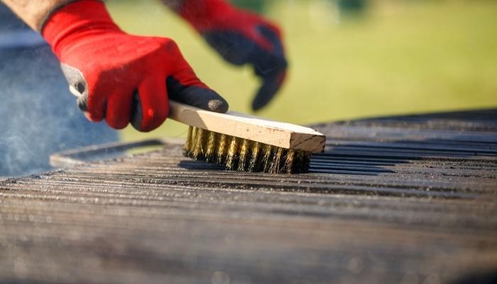 man cleaning bbq grills