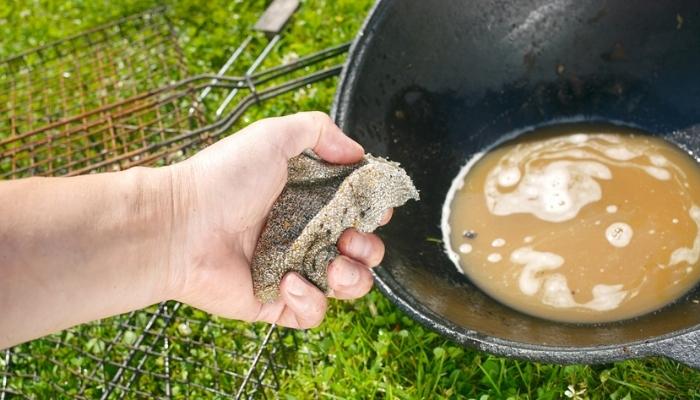 man washing inside of charcoal grill