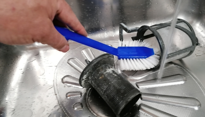 Closeup of someone cleaning the dishwasher filter