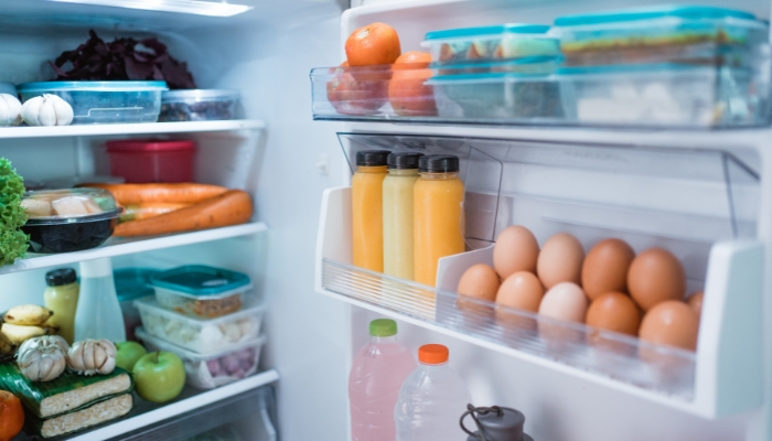 A neatly organized refrigerator with most of the food covered