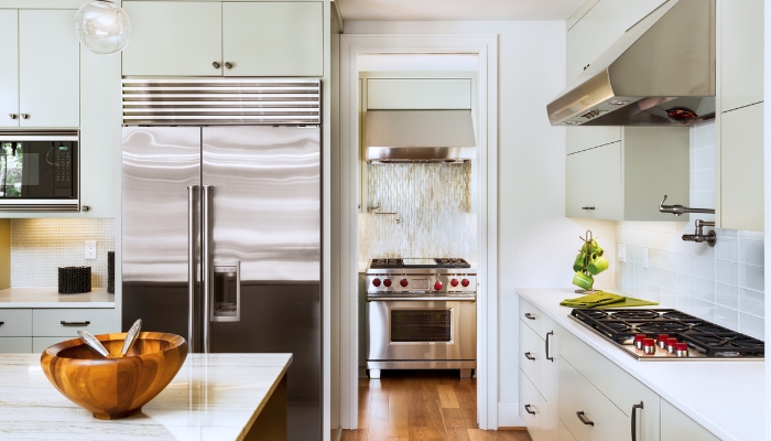 A luxury chef’s kitchen with a professional stainless steel appliances and bright cabinets.