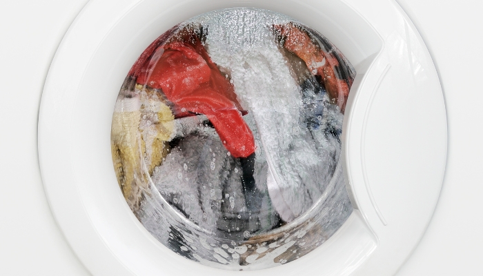 Soap and towels/blankets spin in a closed white washer