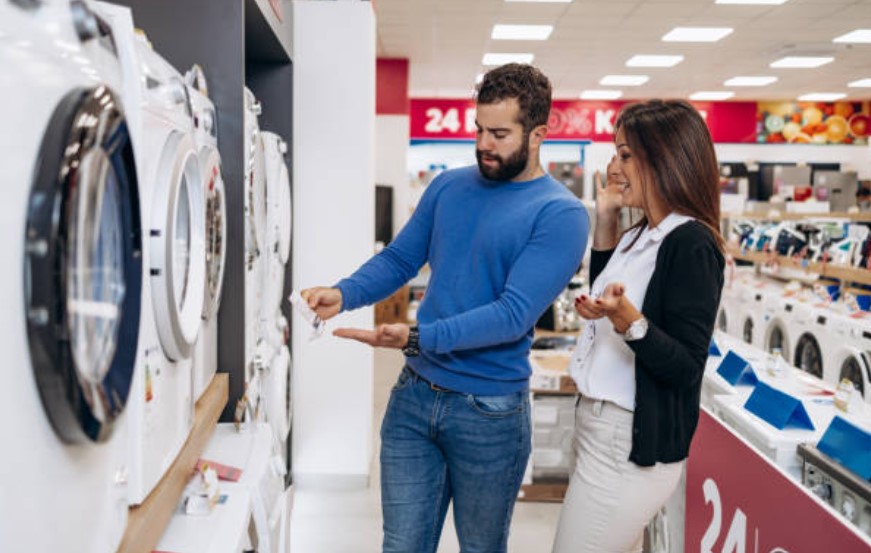 man and woman finding a sale on a washing machine 