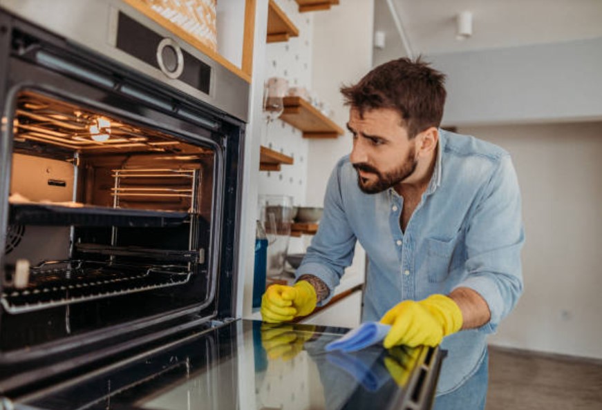 man looking confused in front of oven