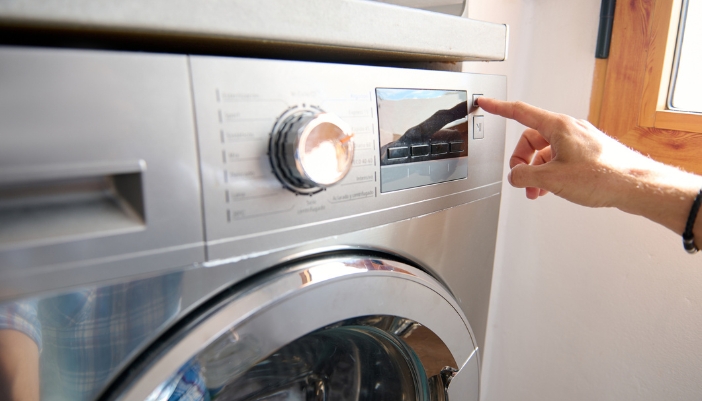 Closeup of a hand selecting a dryer settings