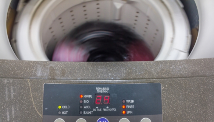 A closeup of a washer spinning clothes