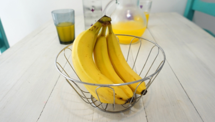 Bananas in a wire bowl, separate from other fruit