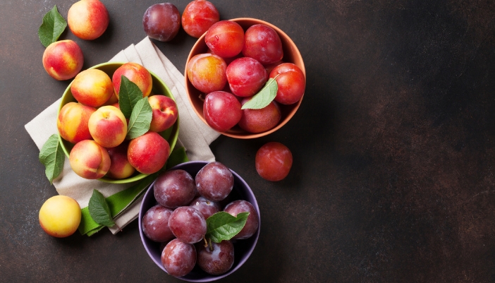 An assortment of stone fruits in a bowl