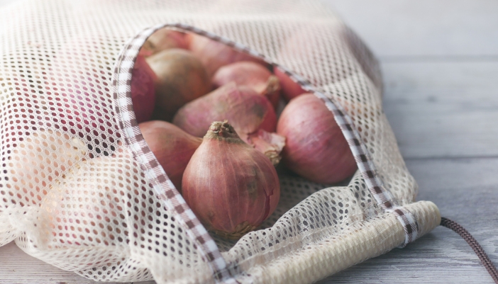 A mesh bag full of onions