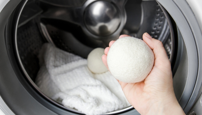 Closeup of someone taking wool dryer balls out of the dryer