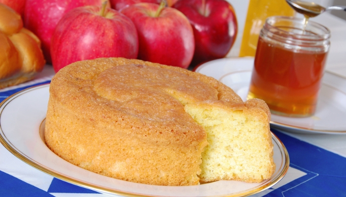 A spatula removes a slice of honey cake from a plate.