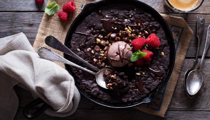 Brownies in cast iron skillet with ice cream topping