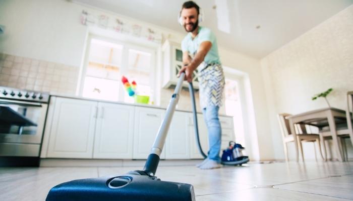 Man vacuuming kitchen