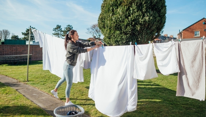 woman hanging sheets to dry