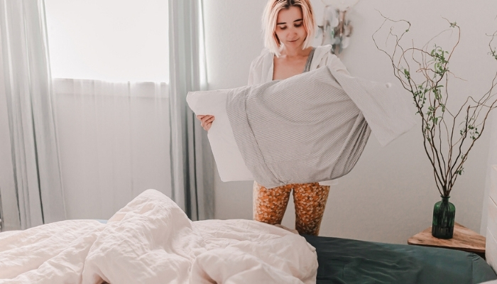 woman removing pillows from bed