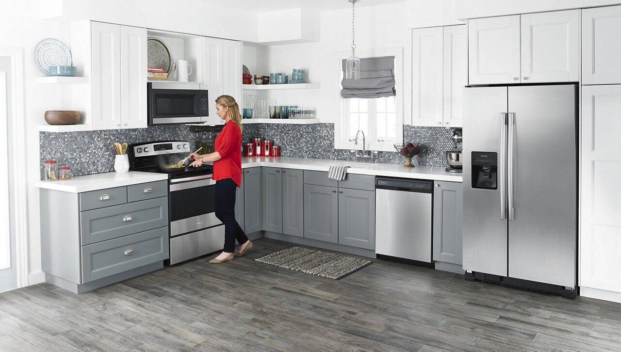 A woman cooks on her Amana range in a modern kitchen