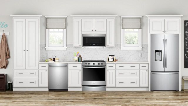 front view of a modern white kitchen with stainless steel appliances
