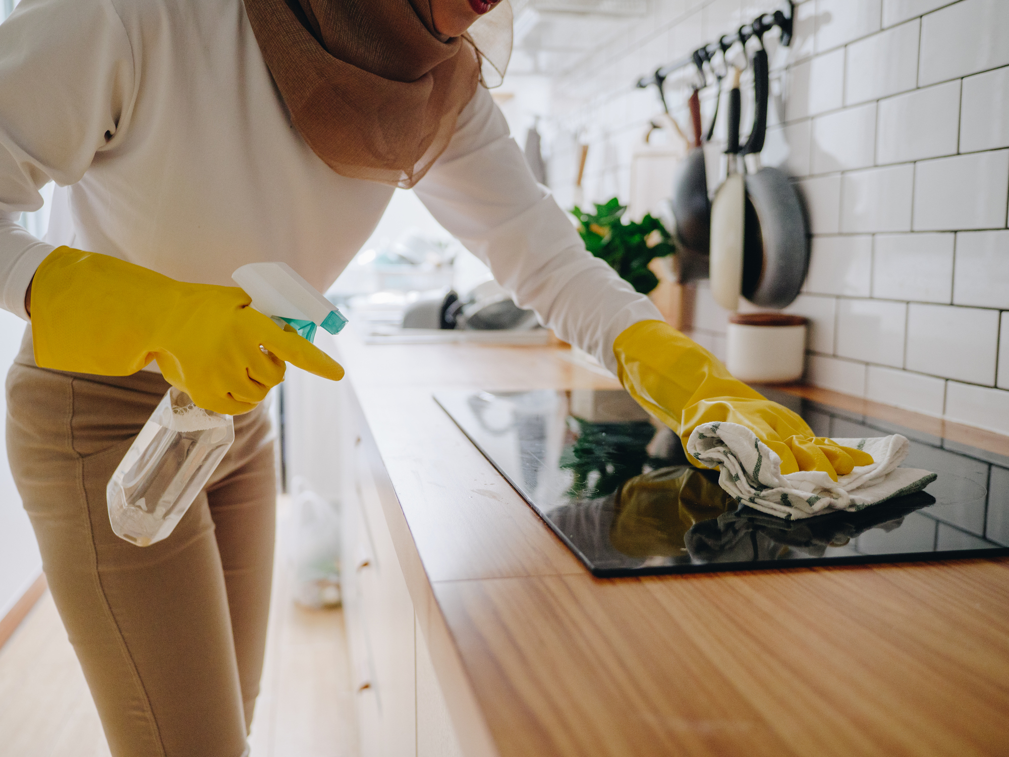 woman cleaning black ceramic stovetop