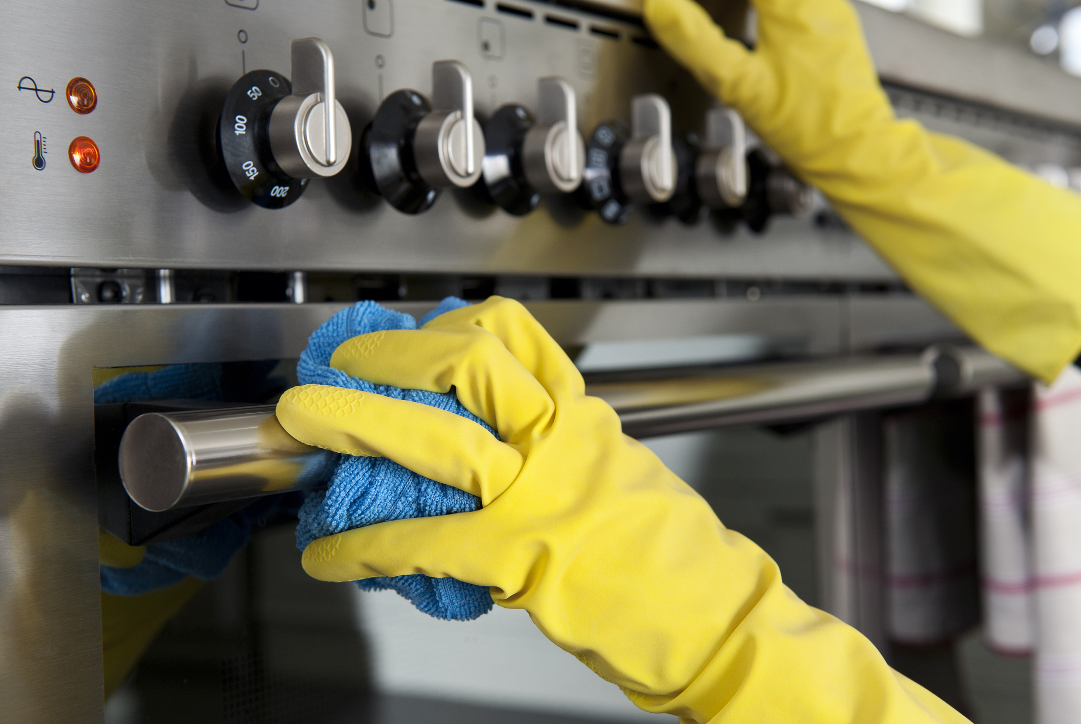 gloved hand cleaning oven