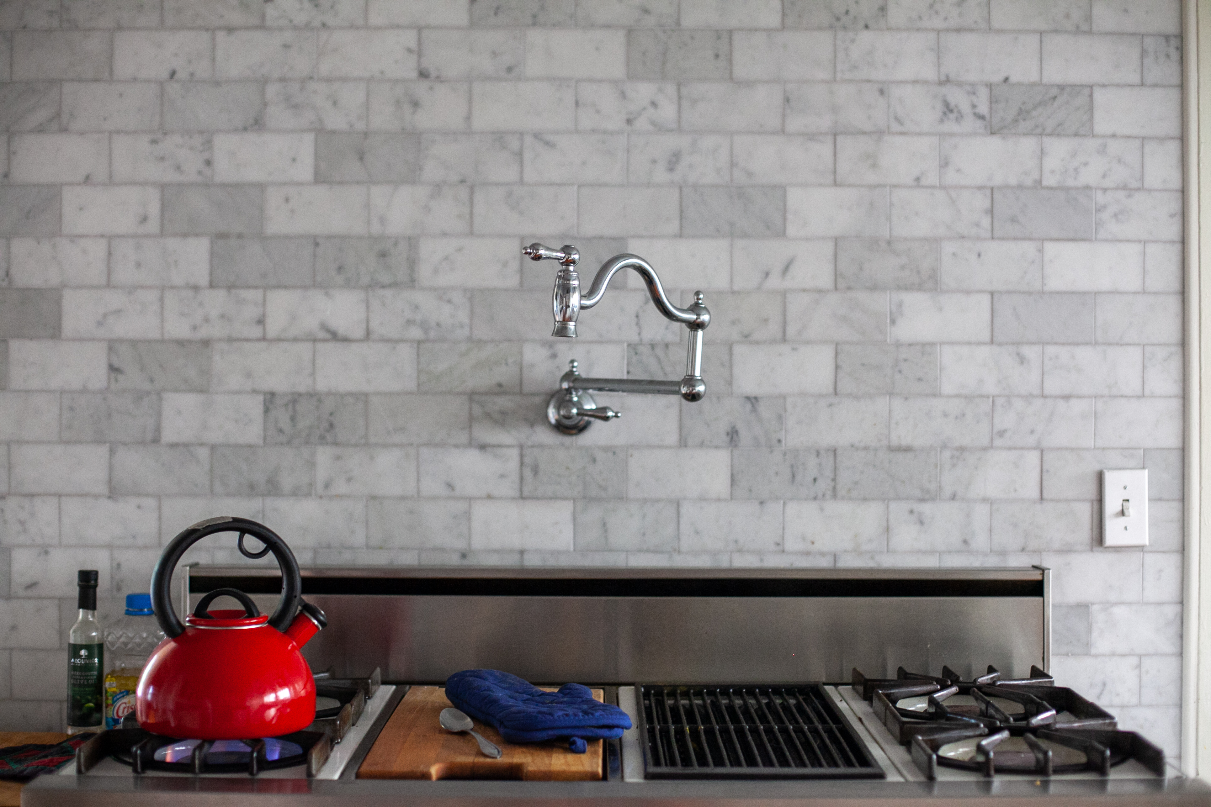 traditional pot filler faucet over gas cooktop