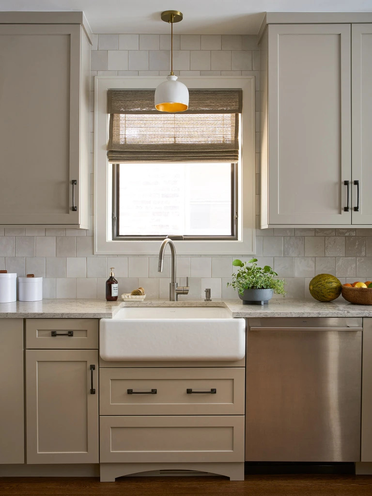 Front view of a Monogram dishwasher next to a farmhouse sink in Robin Titus’ Chicago Oak Park bungalow kitchen remodel 